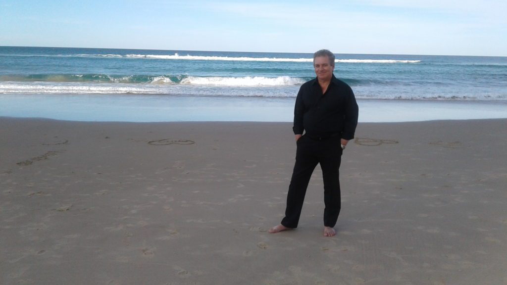 John Robert on the beach barefoot